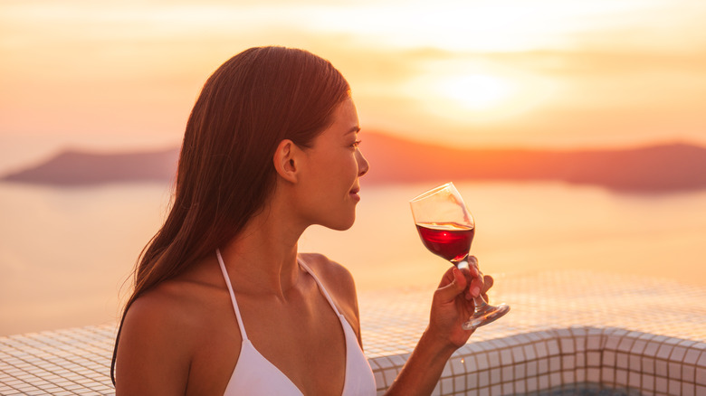 woman sipping red wine sunset