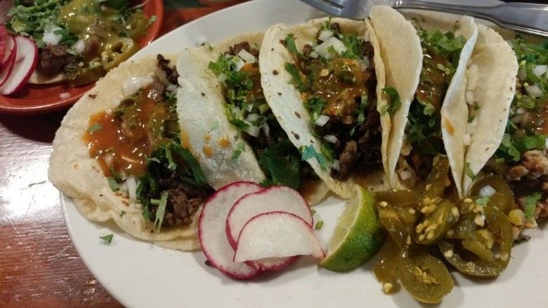a plate of tacos with garnish
