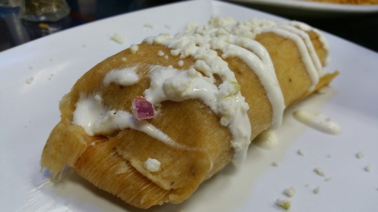 a pork tamale with crema and cheese