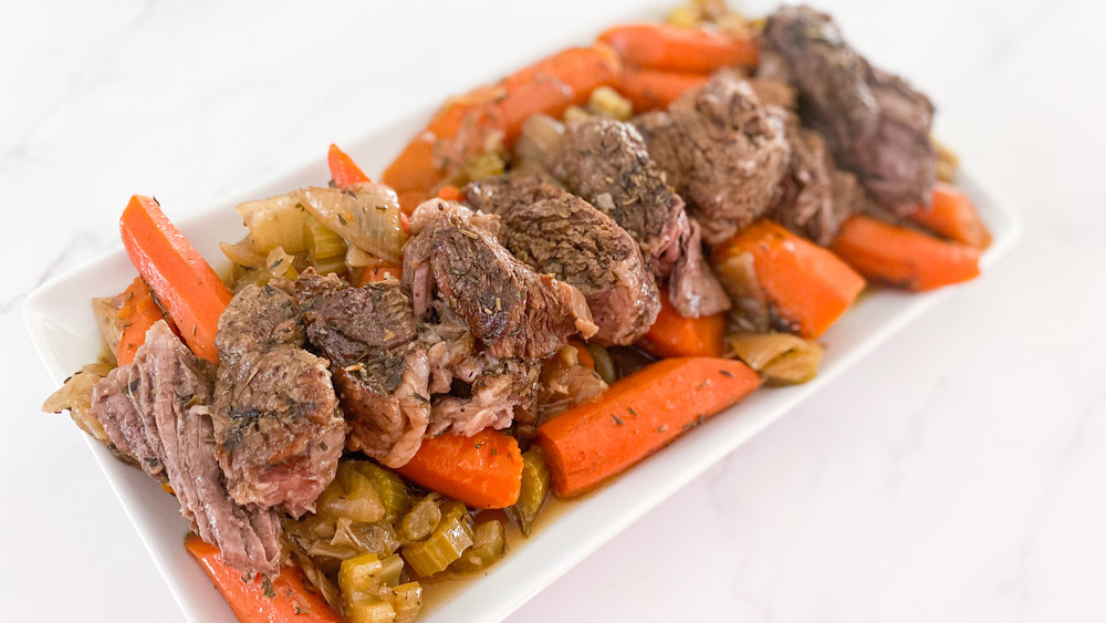 roast beef on platter with carrots and celery