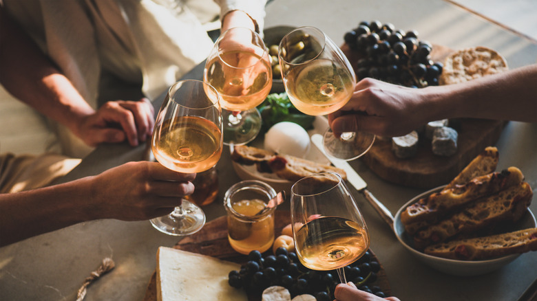 People clinking rosé wine glasses