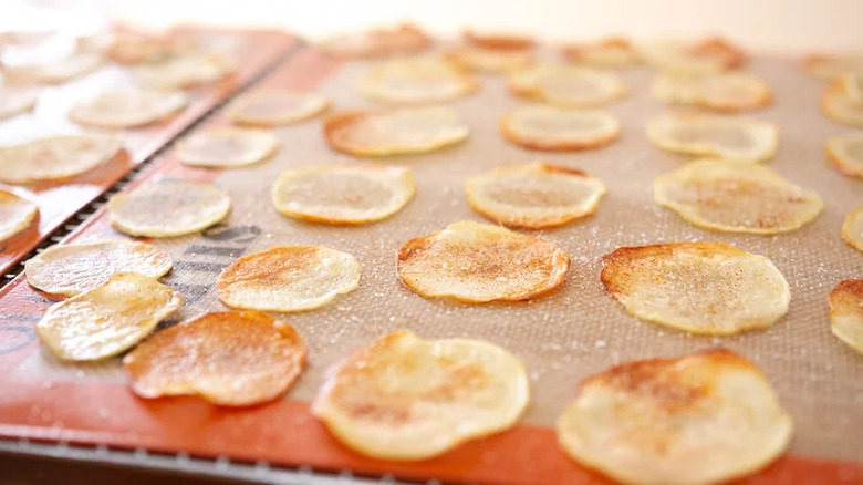 Homemade potato chips on a silicone pad lining a baking rack