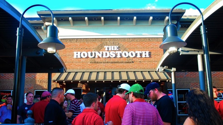 Front a brick building with a packed crowd of people outside