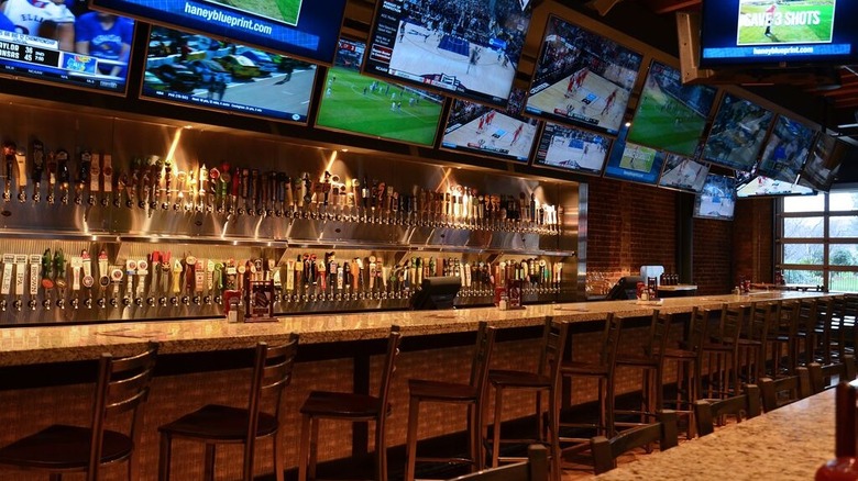 Bar counter with television screens lined up against the wall