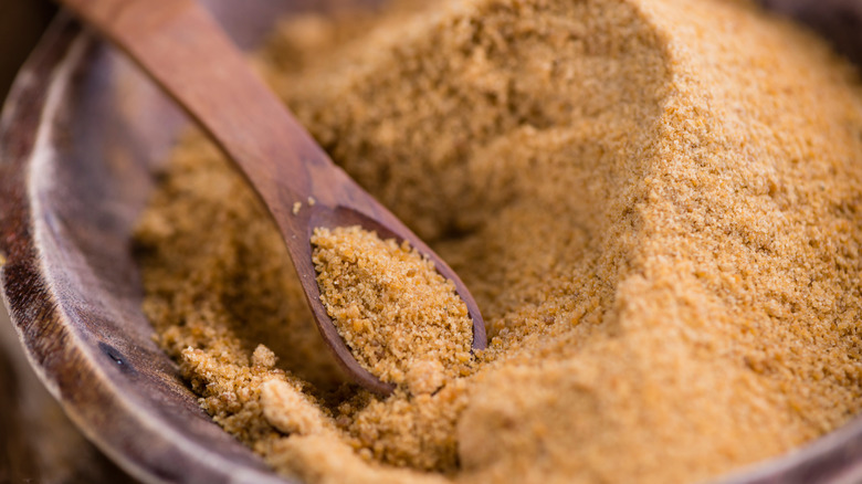 Light brown coconut sugar with wooden spoon