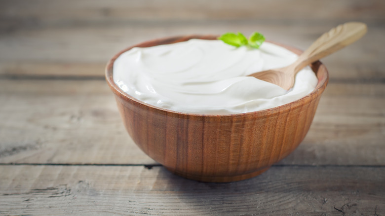 Greek yogurt in wooden bowl with spoon