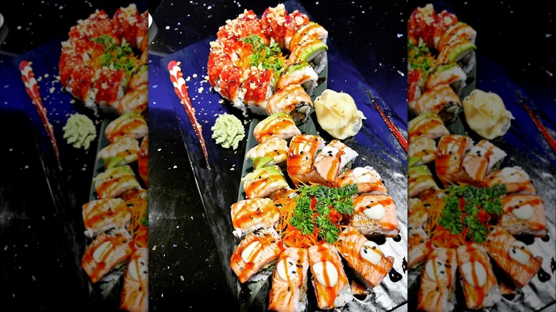 Three sushi rolls, Wham bam Birmingham, double shrimp and hot Asian roll on a table alongside ginger and wasabi