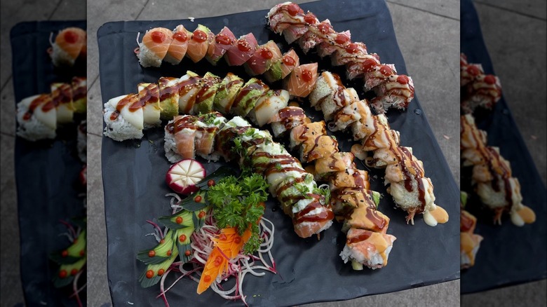 Sushi board with the following rolls: aquaman, pearl harbor, anger management, tomahawk, twilight, and dr. strange.