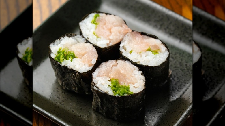 Yellowtail handroll on a square plate.