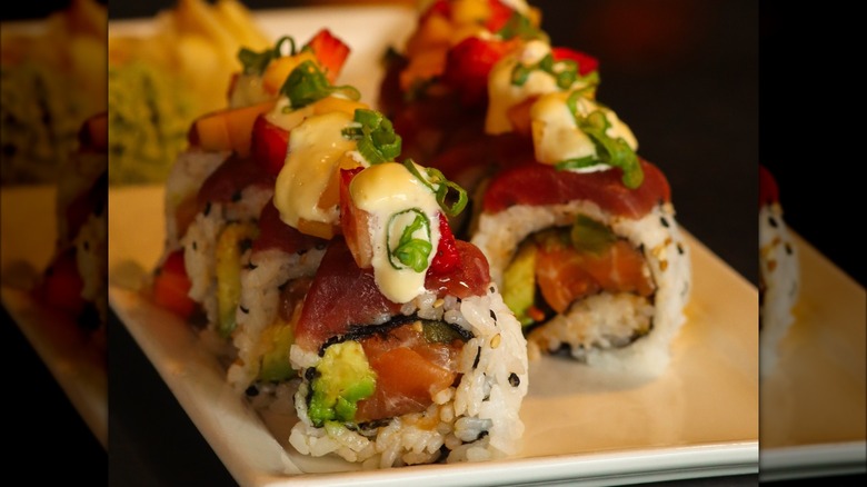 Queen of Hearts roll, made with spicy salmon, yellowfin tuna, avocado, cucumber, jalapeño, mango, scallion, strawberry pepper jelly, cilantro