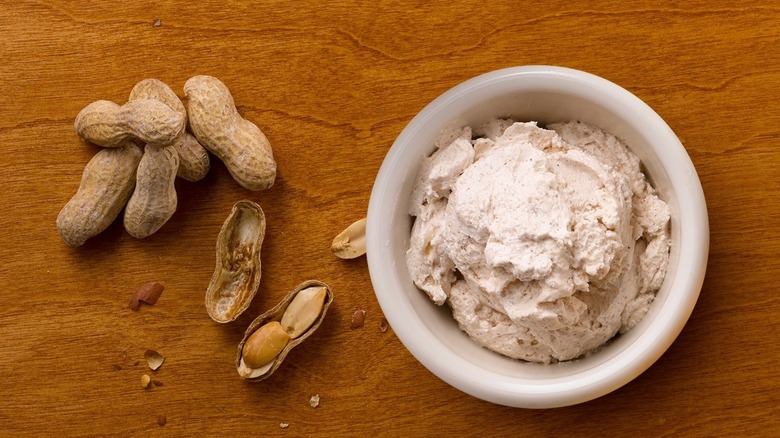 A dish of honey butter from Texas Roadhouse is next to a pile of peanuts