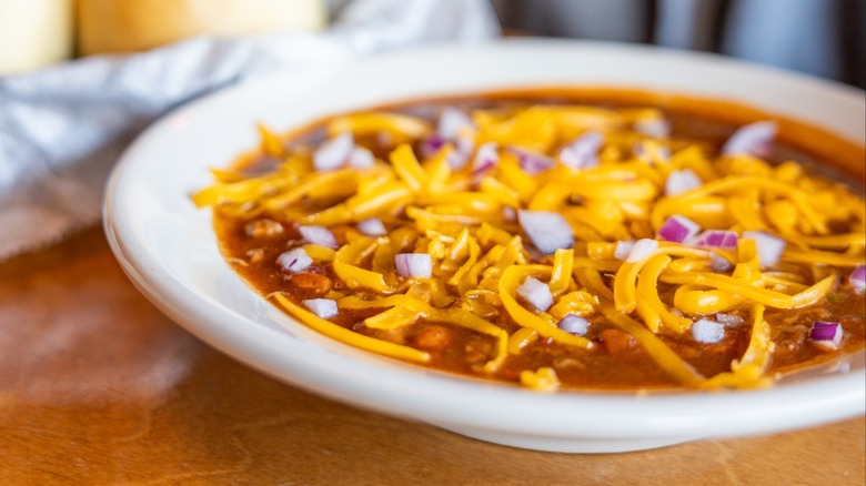 A bowl of chili topped with shredded cheese