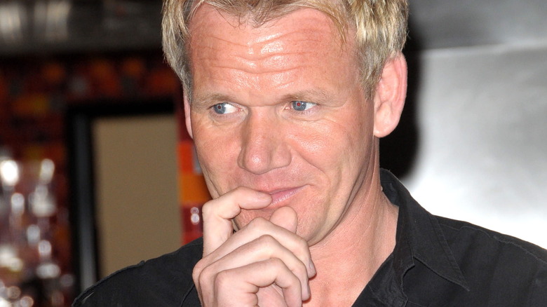 Gordon Ramsay holding fingers to his mouth with side gaze