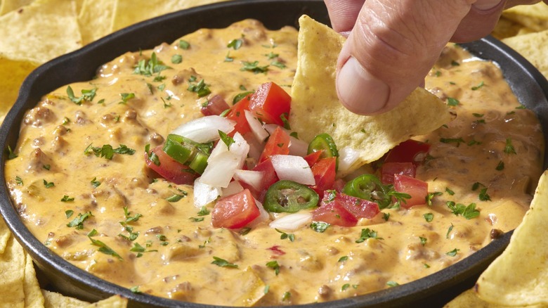 Dipping chip into nacho sauce