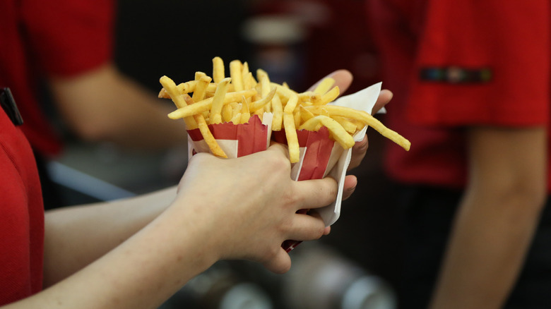 fast food employee holding fries