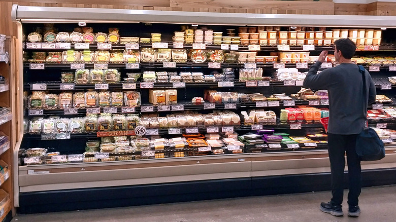 A shopper browsing refrigerated items at Trader Joe's