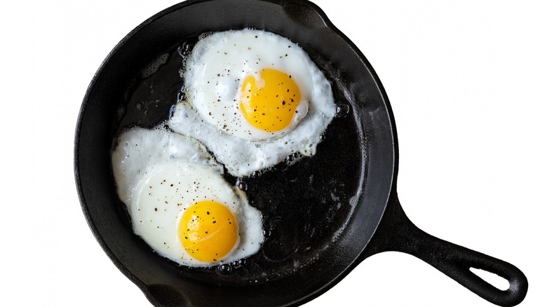 Two eggs frying in pan