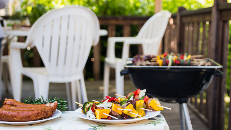 sausages and kabobs on a grill and table