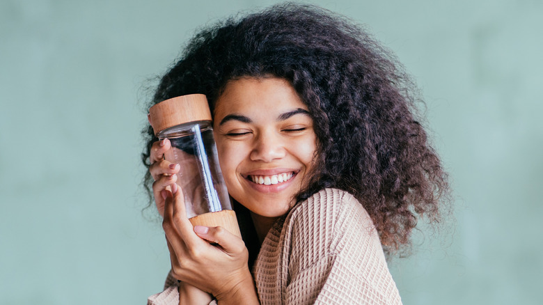 woman hugs reusable water bottle 