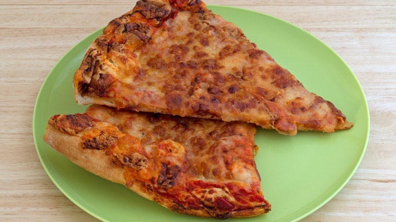 cold pizza slices on green plate