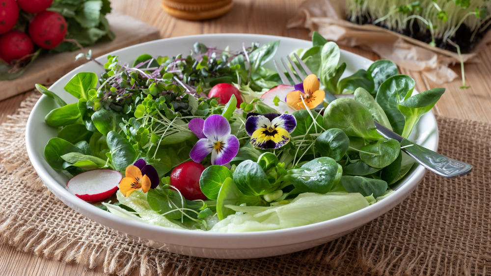 Salad of greens, flowers, and tomatoes