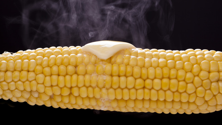 Close up of corn on the cob with melted butter and steam