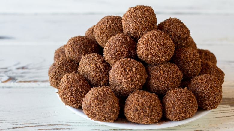 Plate piled high with rum balls covered in chocolate shavings