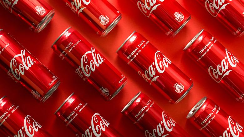 red cans of coca-cola against red background