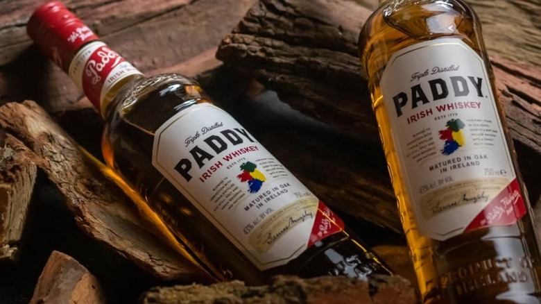 Two bottles of Paddy Irish Whiskey on wooden background