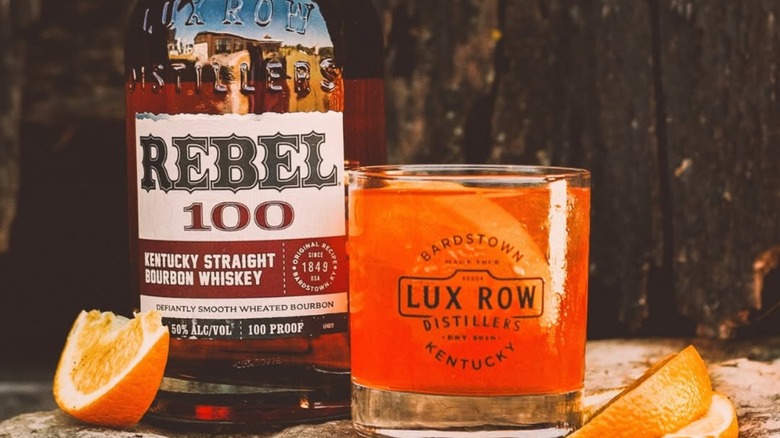 Bottle of Rebel 100 with Lux Row cocktail glass