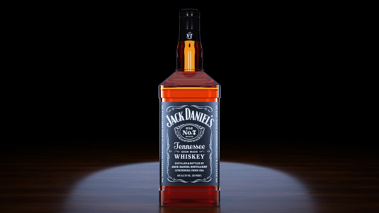 Bottle of Jack Daniel's on wood grain table black background