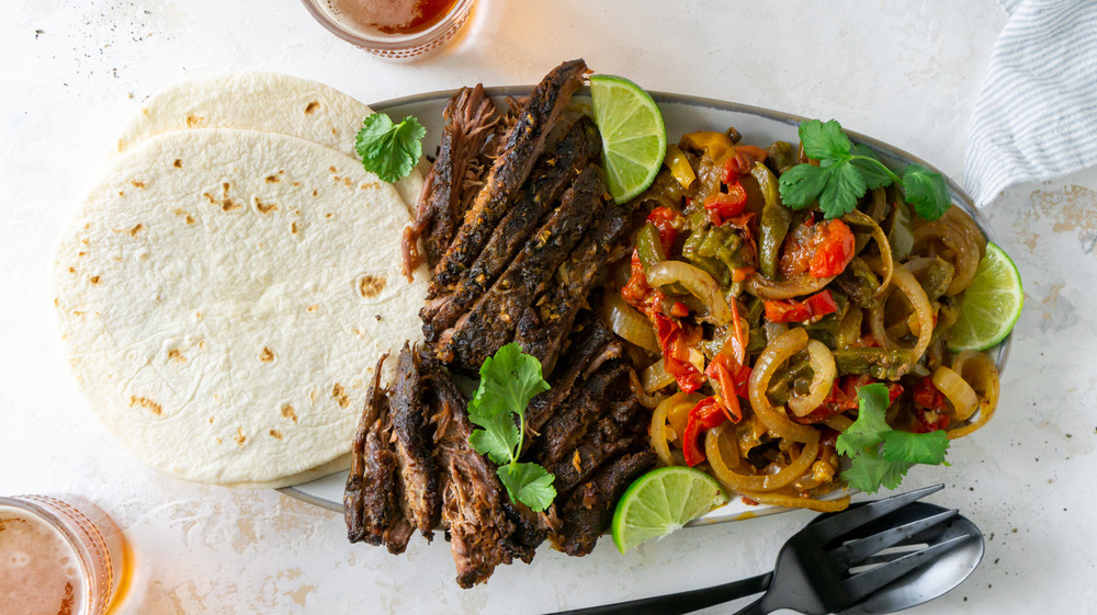 fajita ingredients with tortillas on gray plate