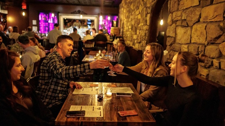 A group of people enjoying glasses of wine on a table at a bar
