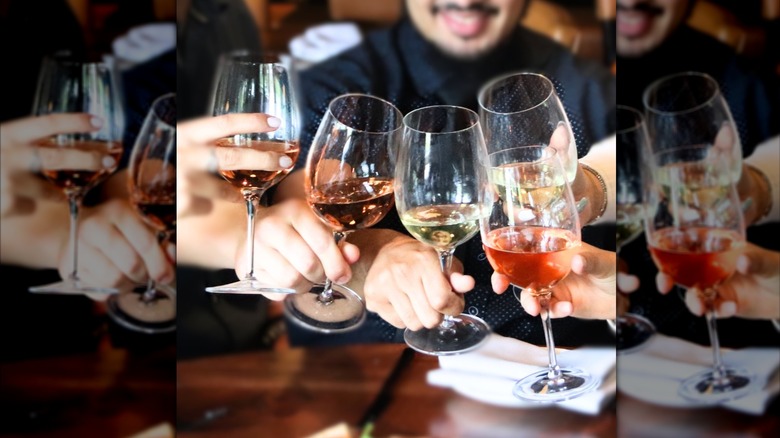 people clinking 5 glasses of wine