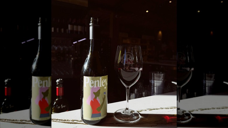 A glass and a bottle of Penley Wine.