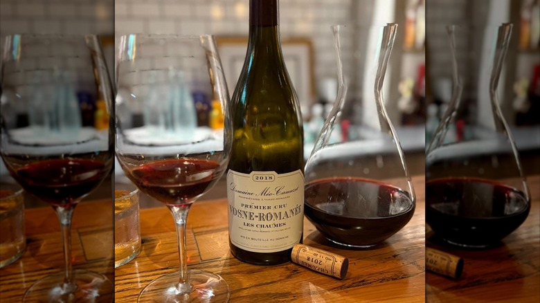 A bottle of wine alongside a decanter and a glass