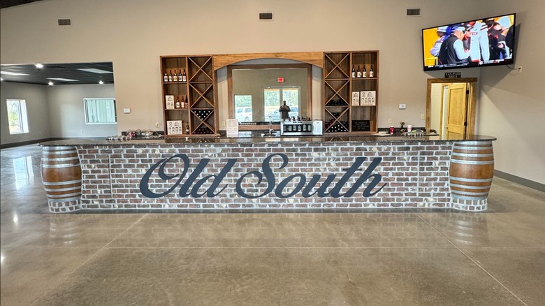 A brick wine tasting bar with Old South written on the front of it with shelves of wine bottles behind
