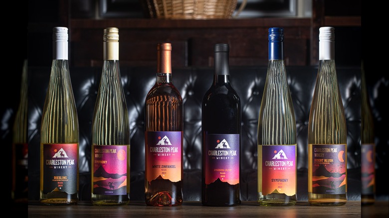 Six different wine bottles lined up on a table with Charleston Peak Winery labels on them