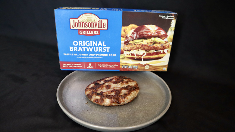 Johnsonville brat patty on plate next to package