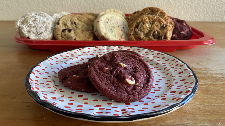 plated red velvet cookies in front of cookie tray