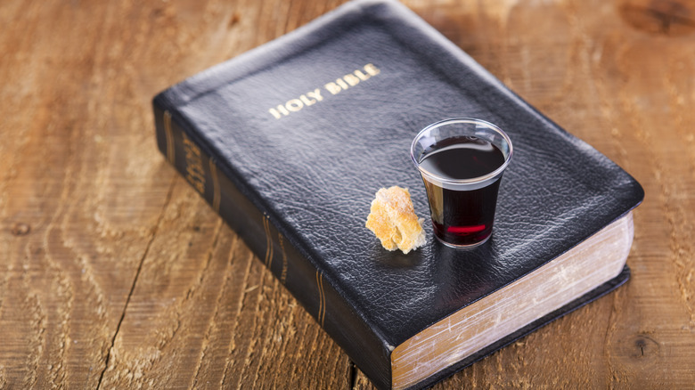 Bible with cup of wine and piece of bread