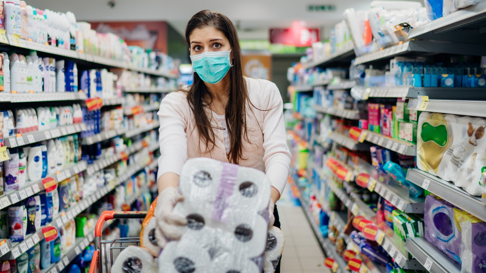 Woman buying paper towels with mask