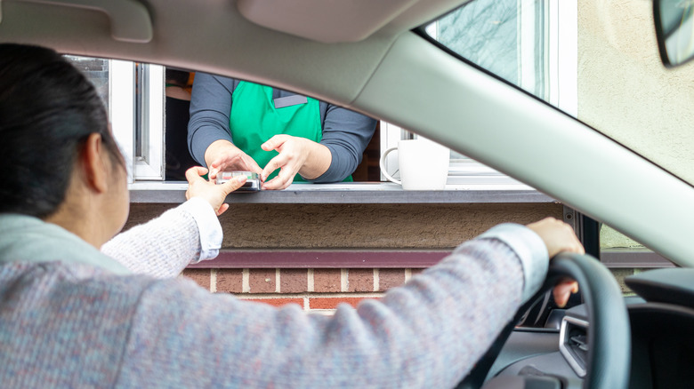 Woman paying at drive-thru