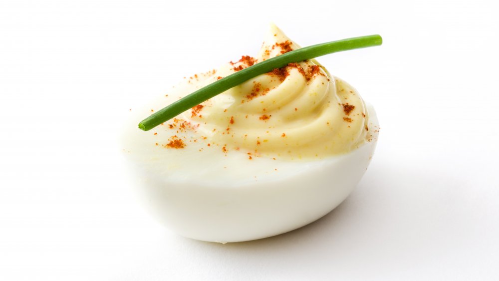 Deviled egg topped with paprika and chives