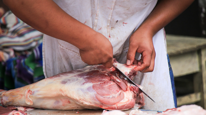 Food worker preparing meat 
