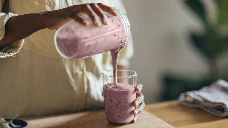 woman pouring smoothie