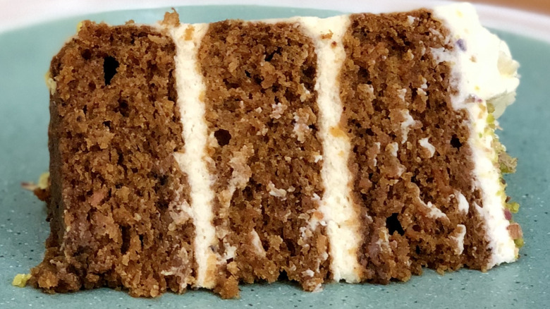 Multi-layered slice of carrot cake with cream cheese frosting