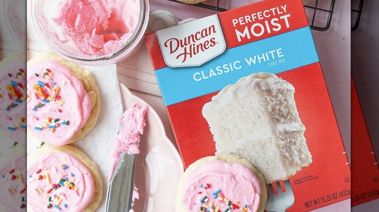Box of Duncan Hines cake with pink frosted cookies
