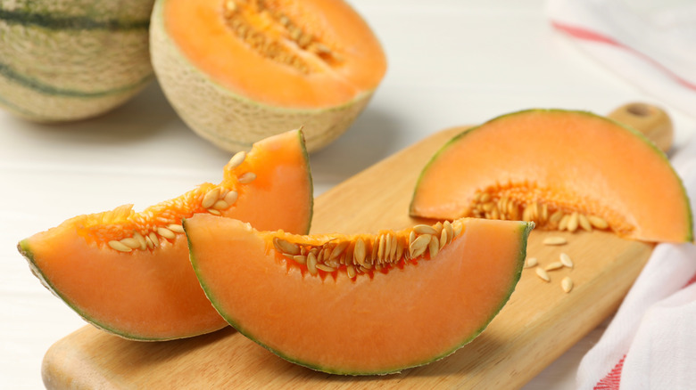 Sliced cantaloupe on wooden board
