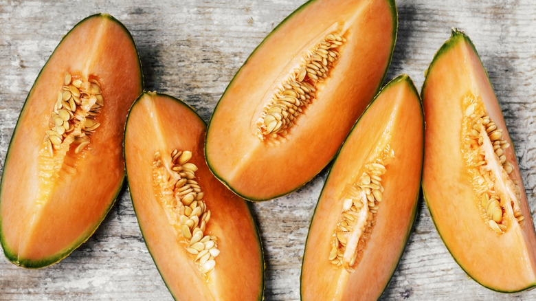 Sliced wedges of cantaloupe on wooden background